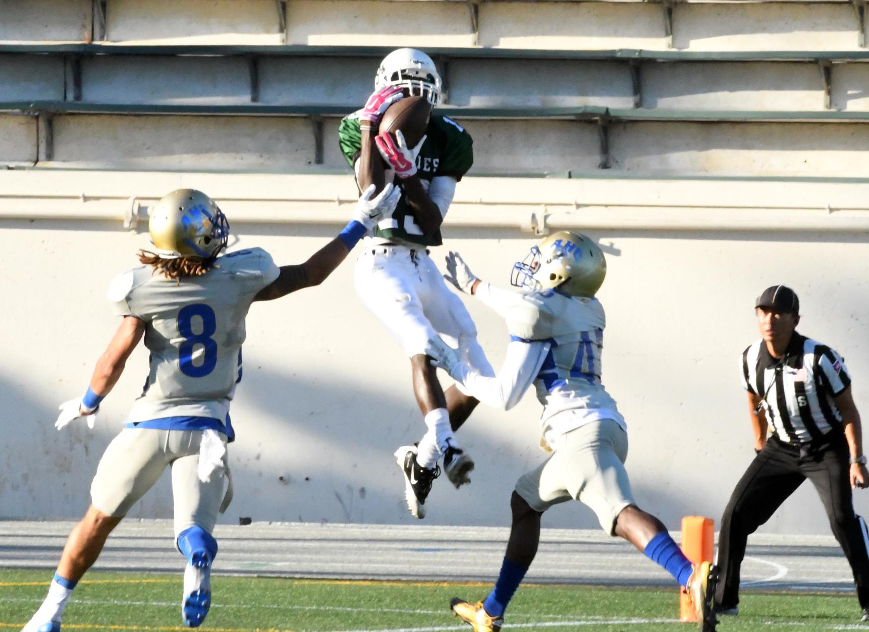 East Los Angeles College freshman wide receiver Kenny Allen catches a 30-yard strike air bound as Hancock freshmen Thomas Leggett and Xavier Dooley are too late. Allen is landing in the end zone for a touchdown with 13:56 left in the third quarter. (Photo by DeeDee Jackson)