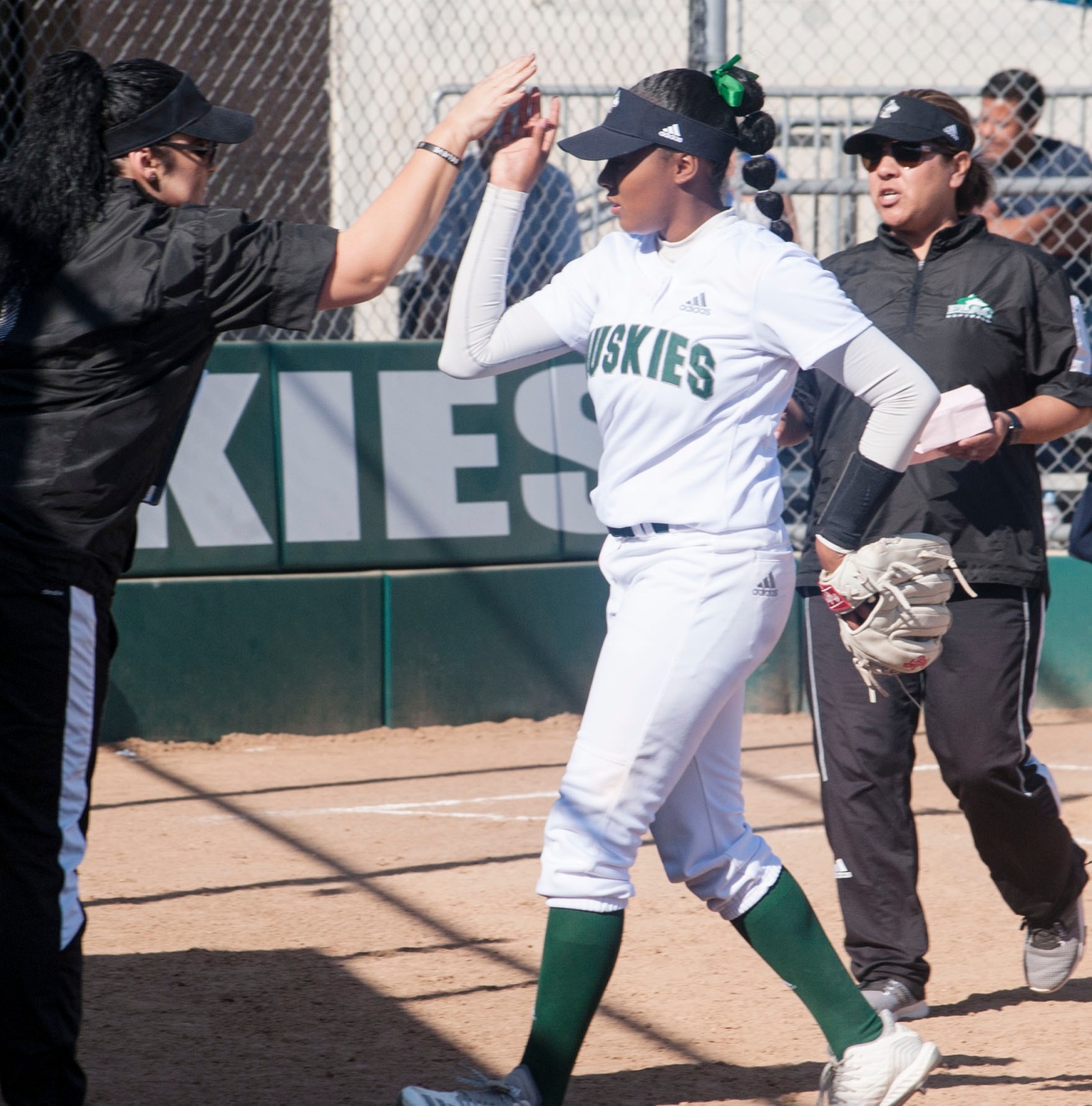 Pitcher Majisty Shomo getting a high-five from the coaches.